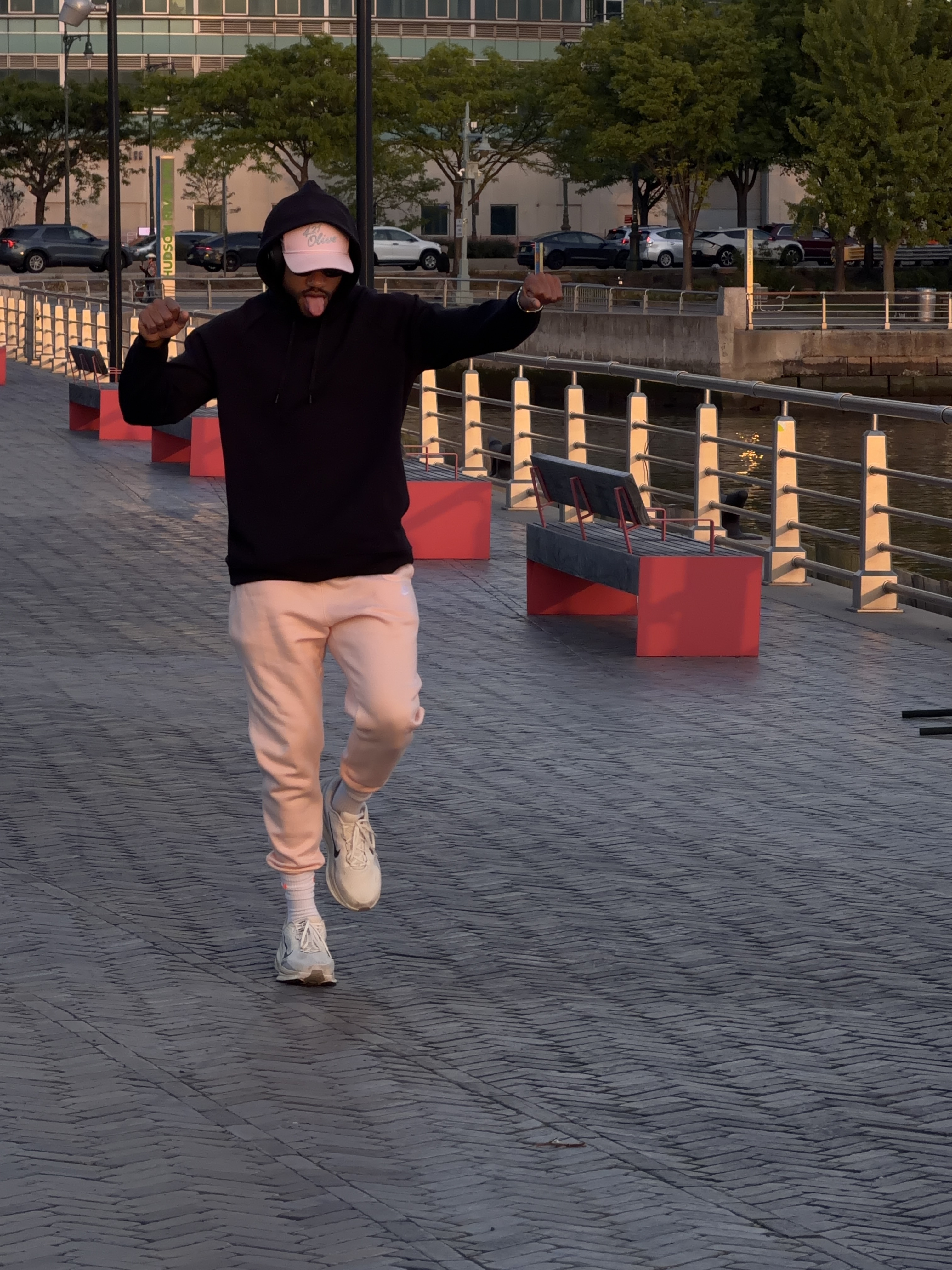 Mid dance move on a pier at sunset, tongue out, no explanation offered