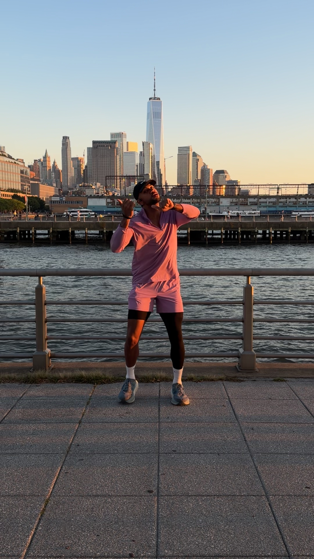 Dramatic pose on a pier at sunset with the Manhattan skyline behind